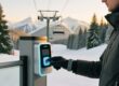 Ski resort guest tapping RFID silicone wristband at lift gate access point