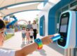 RFID wristbands for kids safety in theme parks, child wearing silicone band with chip, amusement park background, family-friendly technology