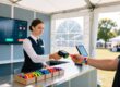 Event staff scanning an RFID wristband at an outdoor festival guest services desk