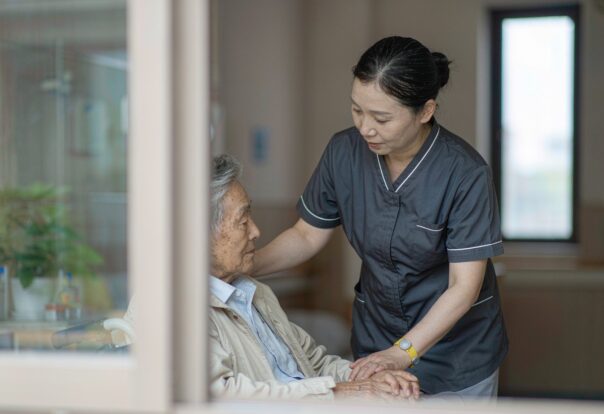 blog-cover-1791942682174 Elderly Japanese patient wearing RFID wristband while nurse scans with handheld reader in modern care facility
