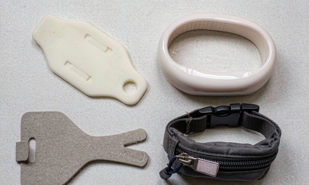 Side-by-side comparison of PVC, silicone, paper, and nylon RFID wristbands on a clean corporate background